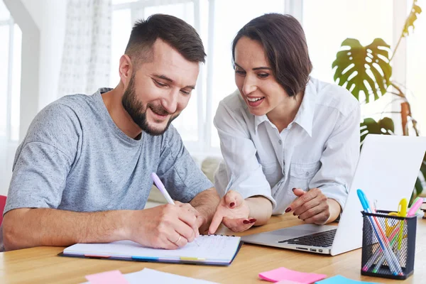 Gorgeous lady telling something while man writing in notebook — Stock Photo, Image