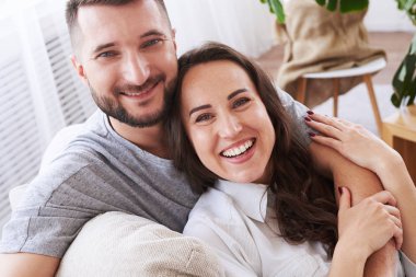 Memnun kız ve sarılma ve kanepede rahatlatıcı erkek