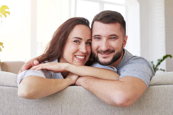 Krásná žena a muž, objímání a odpočinku na pohovce — Stock fotografie