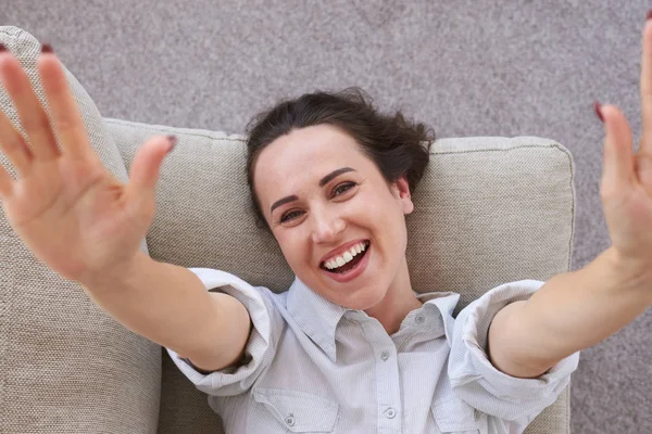 Mulher bonita desfrutando de tempo livre deitado no sofá — Fotografia de Stock