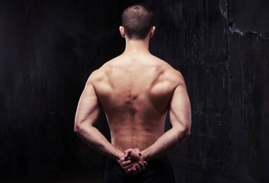 Kas sırt gösteren sağlıklı güçlü genç vücut geliştirmeci
