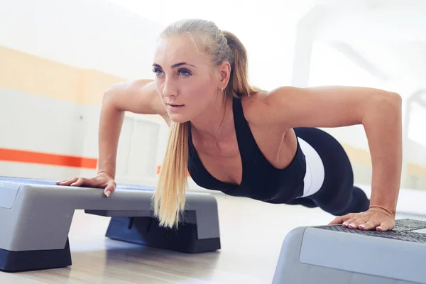Close-up of fitness instructor doing pushup with each hand on tw — Stock Photo, Image