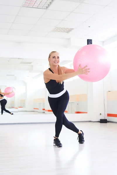 Mujer joven estirándose con fitball en el entrenamiento de pilates — Foto de Stock