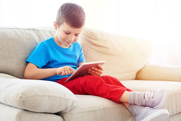 Menino pequeno olhando e tocando uma tela de um tablet — Fotografia de Stock