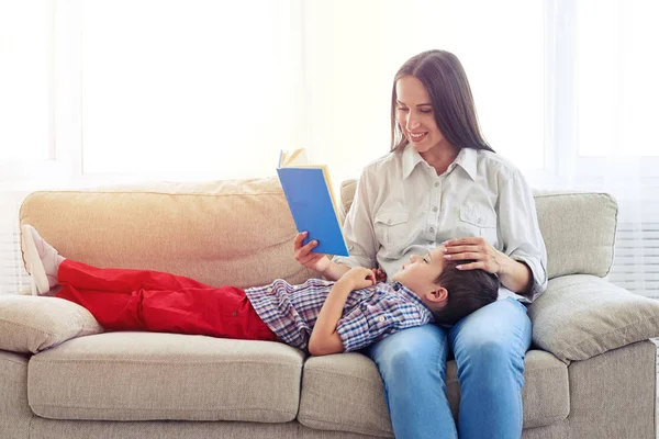 Moeder vergadering met zoon lezen van verhaal binnenshuis — Stockfoto