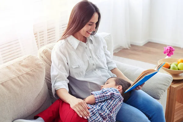 Jeune mère lisant une histoire à l'enfant comme ils se détendre ensemble sur — Photo