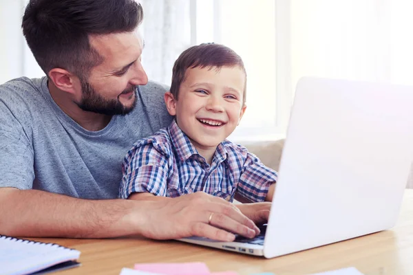 Optimistic father and son spending time together by laying compu — Stock Photo, Image