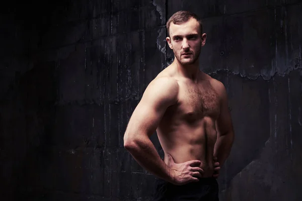 Bodybuilder met getinte gespierd lichaam poseren shirtless — Stockfoto