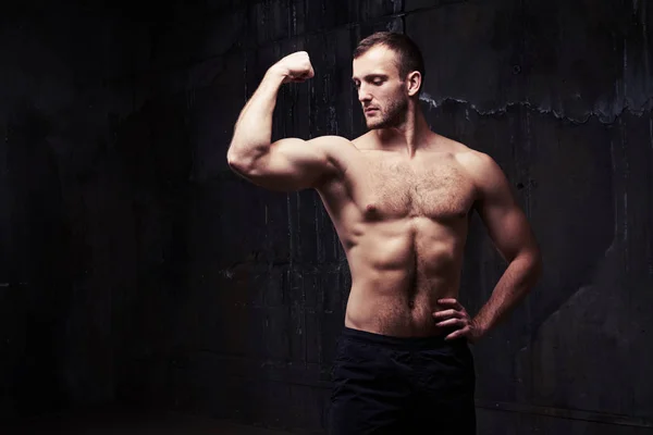 Мужчина без рубашки сгибает мышцы, показывая большое облегчение рук — стоковое фото