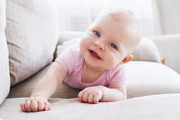 Maravillosa niña pequeña arrastrándose en el sofá —  Fotos de Stock