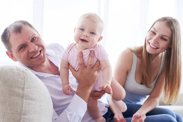 Heerlijke papa bedrijf prachtige baby zittend met vrouw op — Stockfoto