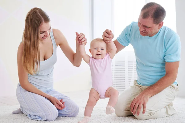 Familia enseñando a caminar al bebé — Foto de Stock