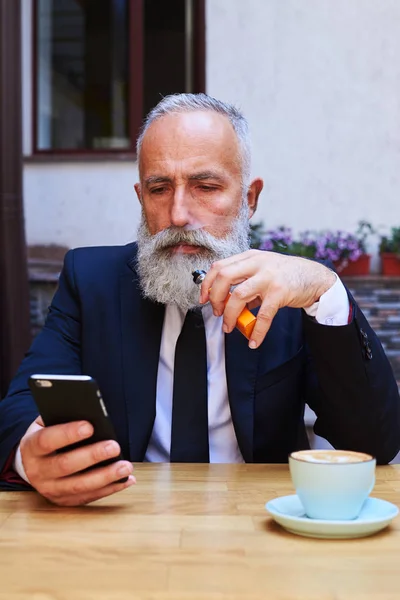 Elegante hombre barbudo mirando el teléfono inteligente —  Fotos de Stock