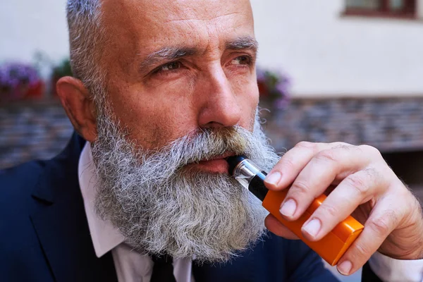 Viejo barbudo macho fumar electrocigarrillo —  Fotos de Stock