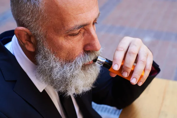 Señor con cara de póquer fumar electrocigarrillo —  Fotos de Stock