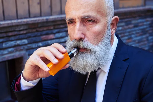 Pensativo hombre de negocios fumar electrocigarrillo —  Fotos de Stock
