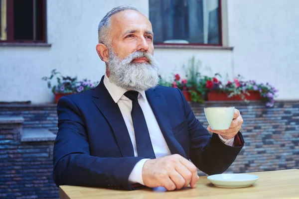 Barbudo masculino beber café enquanto sentado — Fotografia de Stock