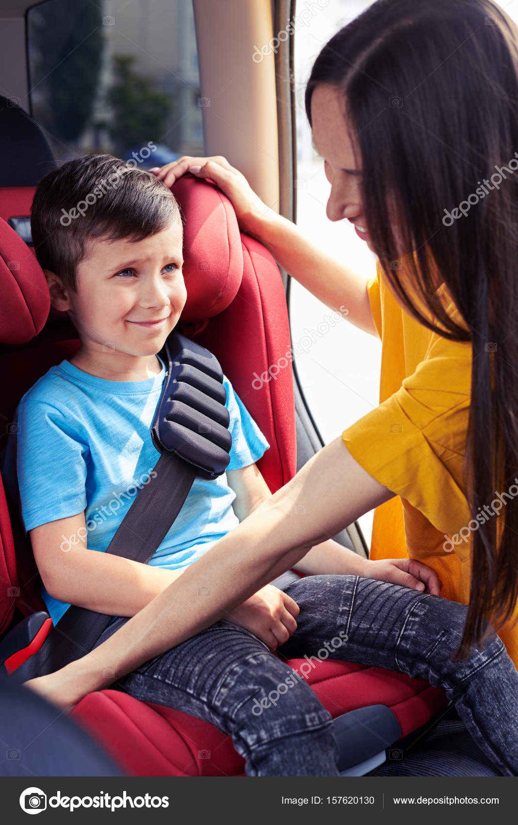 İyi anne bebek oturup oturan oğlu emniyet kemeri tespit etmek Stok