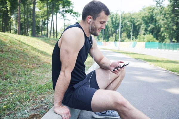 Atleta sorrindo usando smartphone — Fotografia de Stock