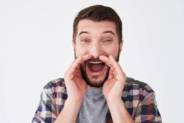 Ung upphetsad skäggig man håller händerna nära munnen medan screami — Stockfoto