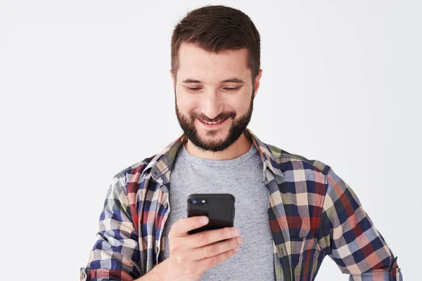 Gelukkig jonge man met baard SMS op mobiel — Stockfoto