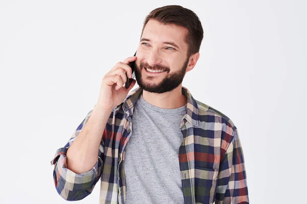 Homme barbu souriant parlant au téléphone tout en se tenant debout — Photo