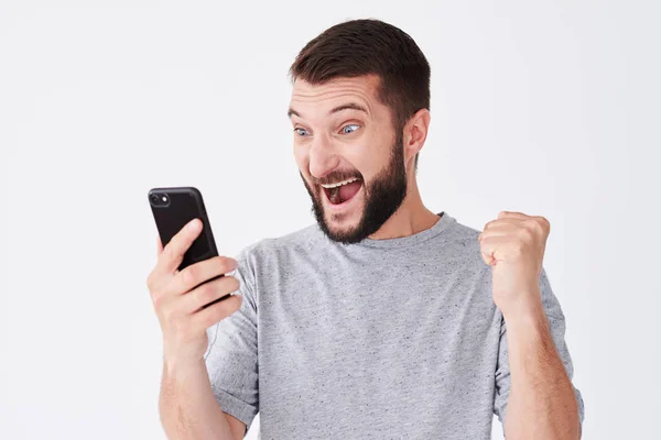 Aufgeregter junger Mann schreit auf seinem Handy — Stockfoto