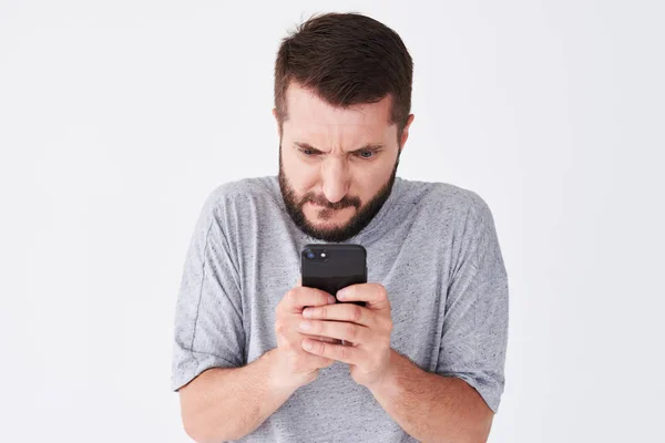 Opgewonden bebaarde man in ingecheckte shirt spelen op smartphone — Stockfoto