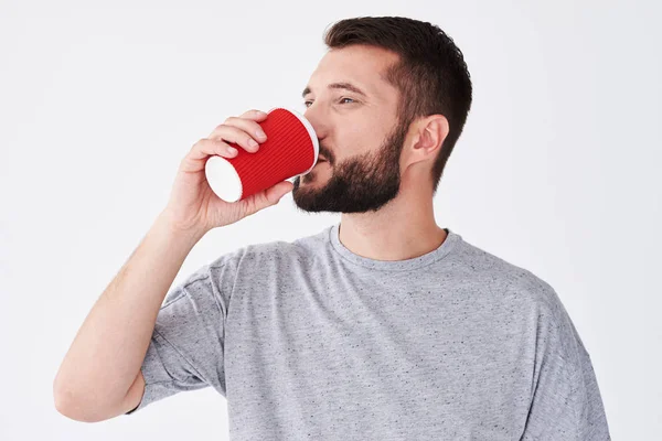 Uomo barbuto sorridente degustazione caffè da vetro di carta — Foto Stock