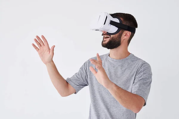 Bearded man using VR glasses trying to touch objects in virtual — Stock Photo, Image