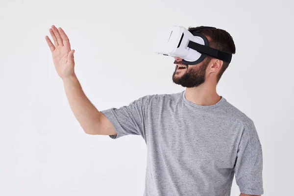 Усміхнений бородатий чоловік використовує окуляри VR, намагаючись торкнутися об'єктів у — стокове фото