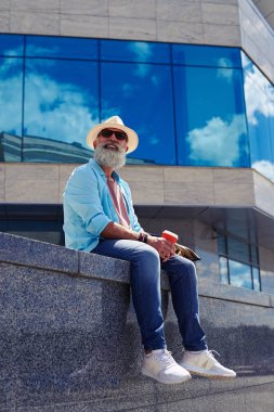 Oturan yaşlı adam gülümseyen