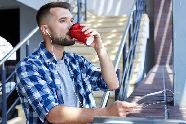 Hombre barbudo guapo escuchando música en una tableta digital —  Fotos de Stock