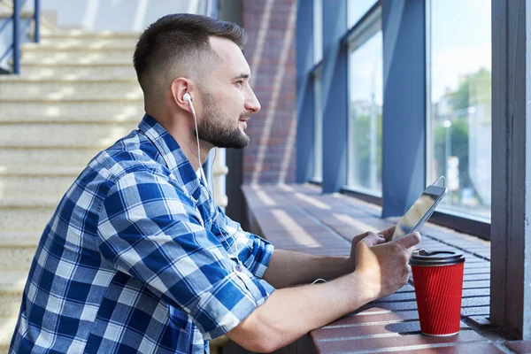 Dromerige bebaarde man luisteren muziek terwijl u door de win — Stockfoto