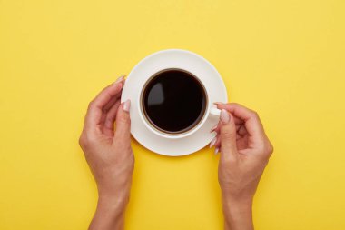 Eller, düz aromatik kahve bir fincan yatıyordu