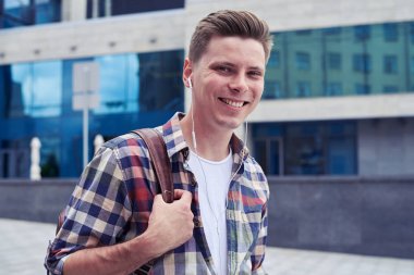 Gülümseyen adam ile şehir merkezinde yürürken kameraya bakan