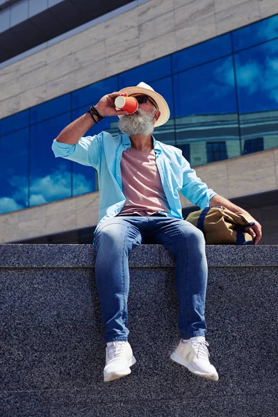 Yaşlı adam bardaktan içiyor