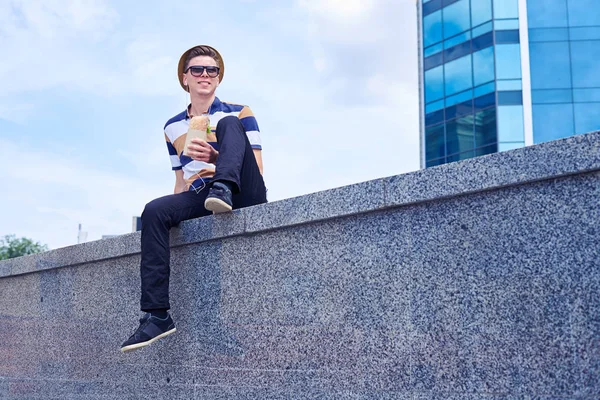 Junger Mann isst Essen zum Mitnehmen in der Innenstadt — Stockfoto