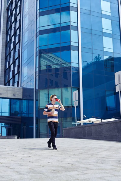 Stylish boy is walking outside and drinking coffee — Stock Photo, Image