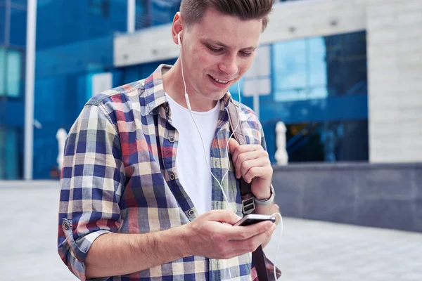 Ehrlicher Student hört Musik, während er etwas in pho sucht — Stockfoto