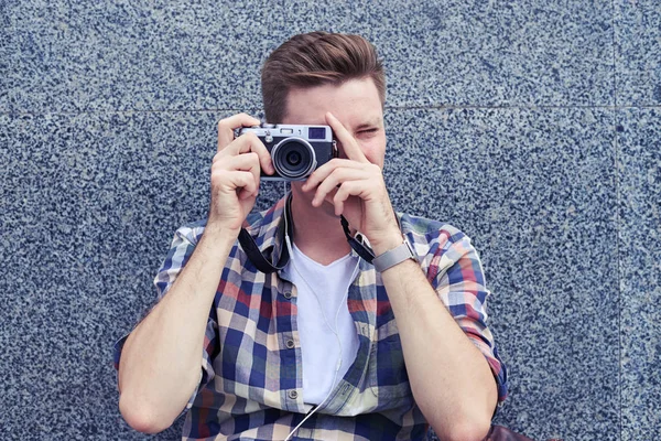 座っているヴィンテージの ca で写真を撮る若い男写真家 — ストック写真