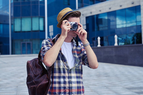 Stylish photographer taking photos with vintage camera 