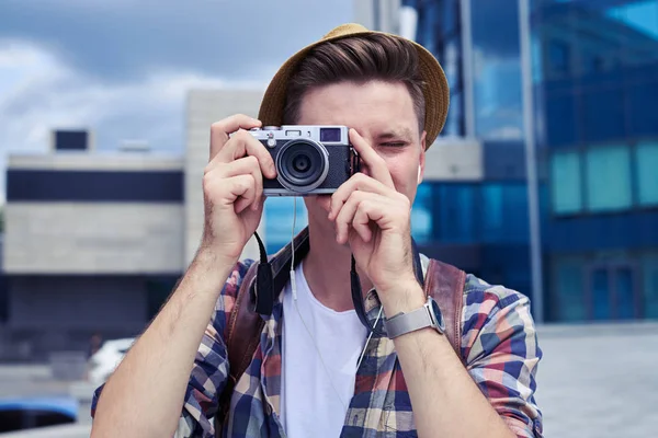 Cheerful young man in hat using old vintage photo camera — Stock Photo, Image