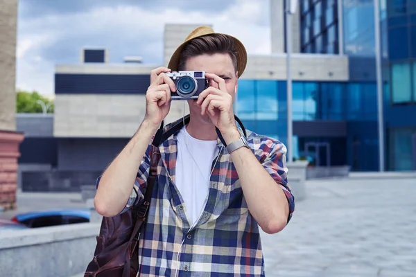 Amazed young man with camera takes photos in downtown — Stock Photo, Image