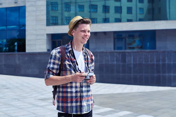 Uomo positivo in cappello con fotocamera retrò camminare all'aperto — Foto Stock