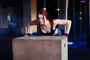 Kadın atlet itme yapıyor ups üzerinde ahşap kutu