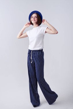 Neşeli kadın ağzına kadar şapka tutarken poz