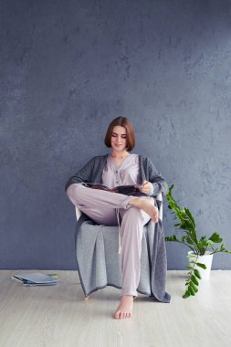 Güzel Bayan koltukta dergi okuma