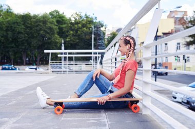 Çekici kadın ile paten Küpeşte altında otururken rahatlatıcı