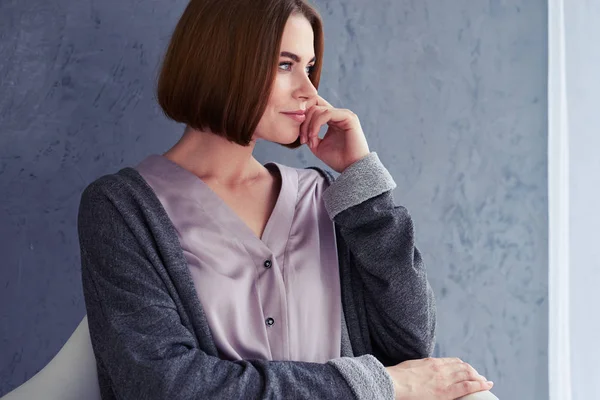 Nice girl relaxing while thinking and sitting on armchair — Stock Photo, Image